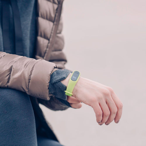 Person wearing a green fitness band outdoors