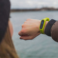 Woman checking her fitness band by a lake