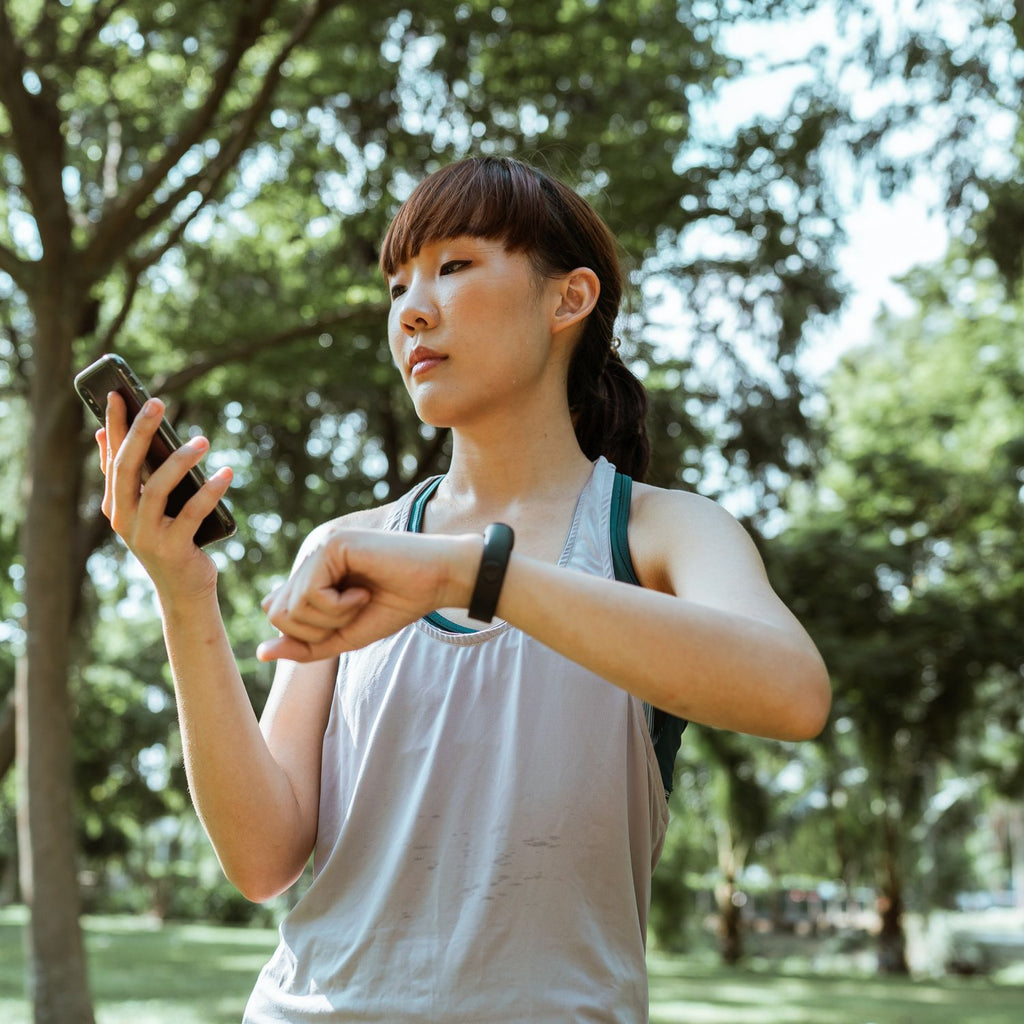 Runner using a phone and fitness band while training