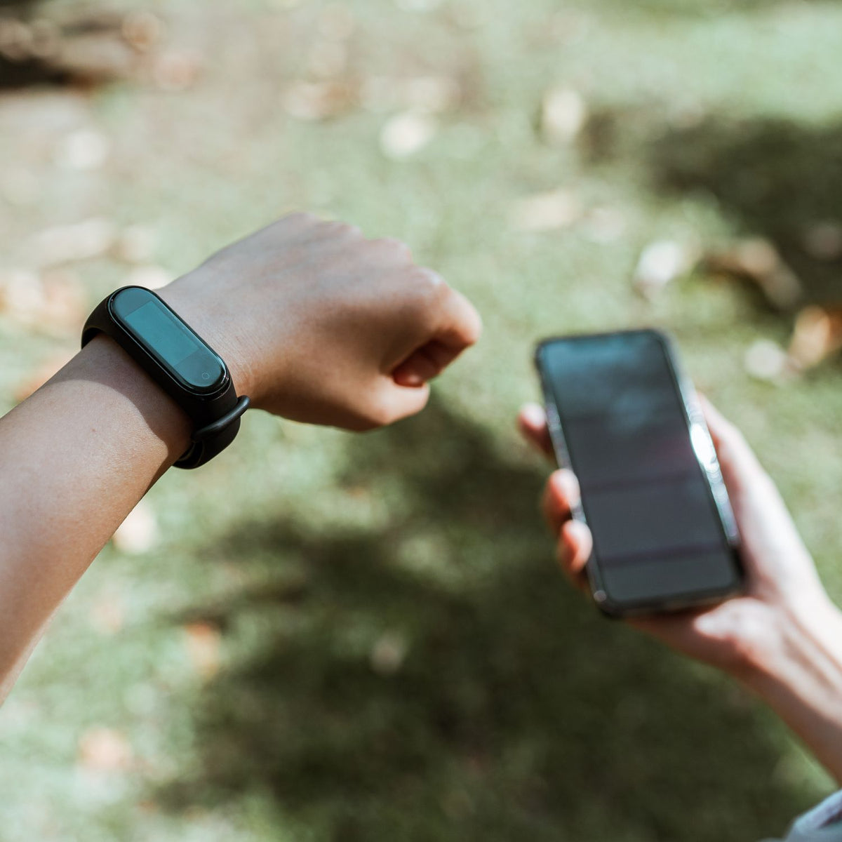 Person wearing a fitness band while using a phone