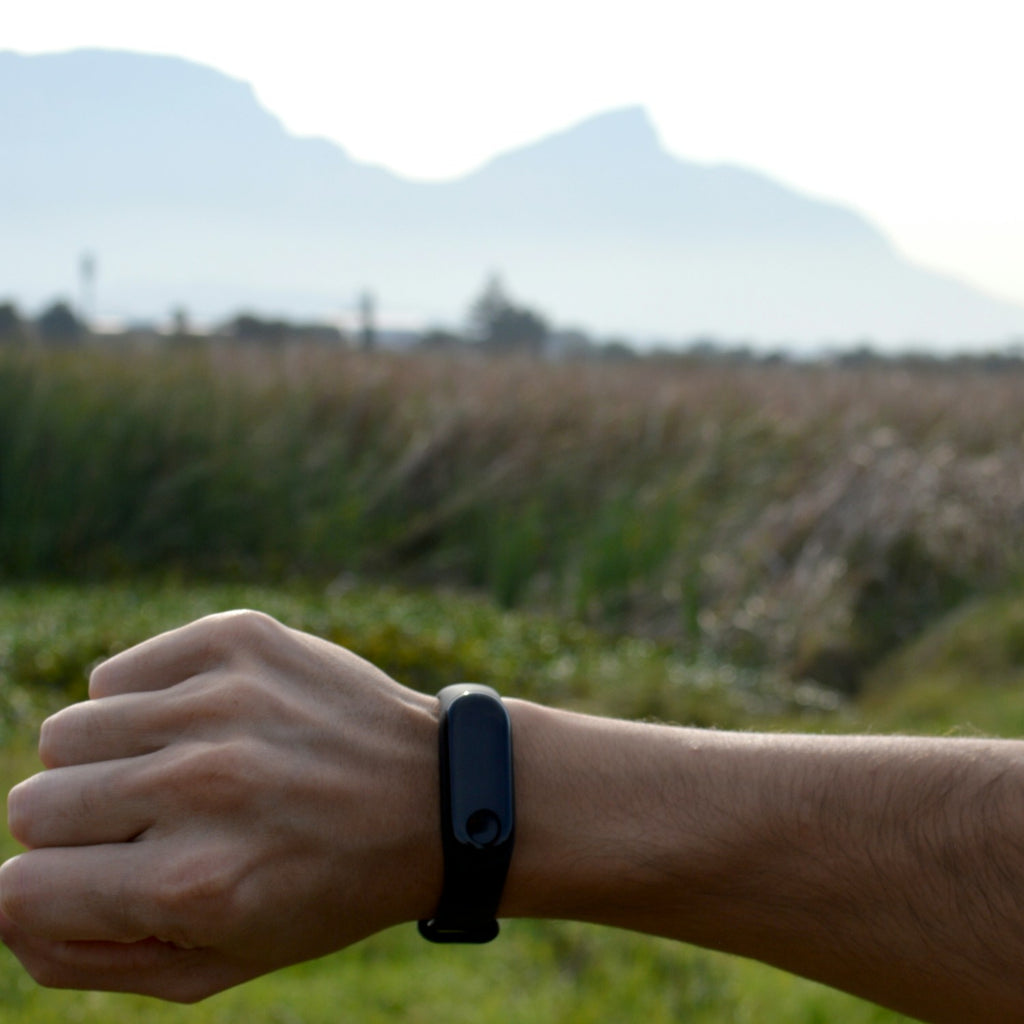 Man checking his fitness band outdoors