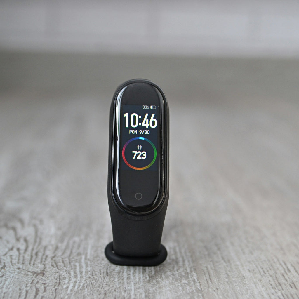 Xiaomi Smart Band fitness tracker standing on a wooden floor