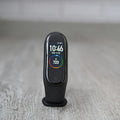 Xiaomi Smart Band fitness tracker standing on a wooden floor