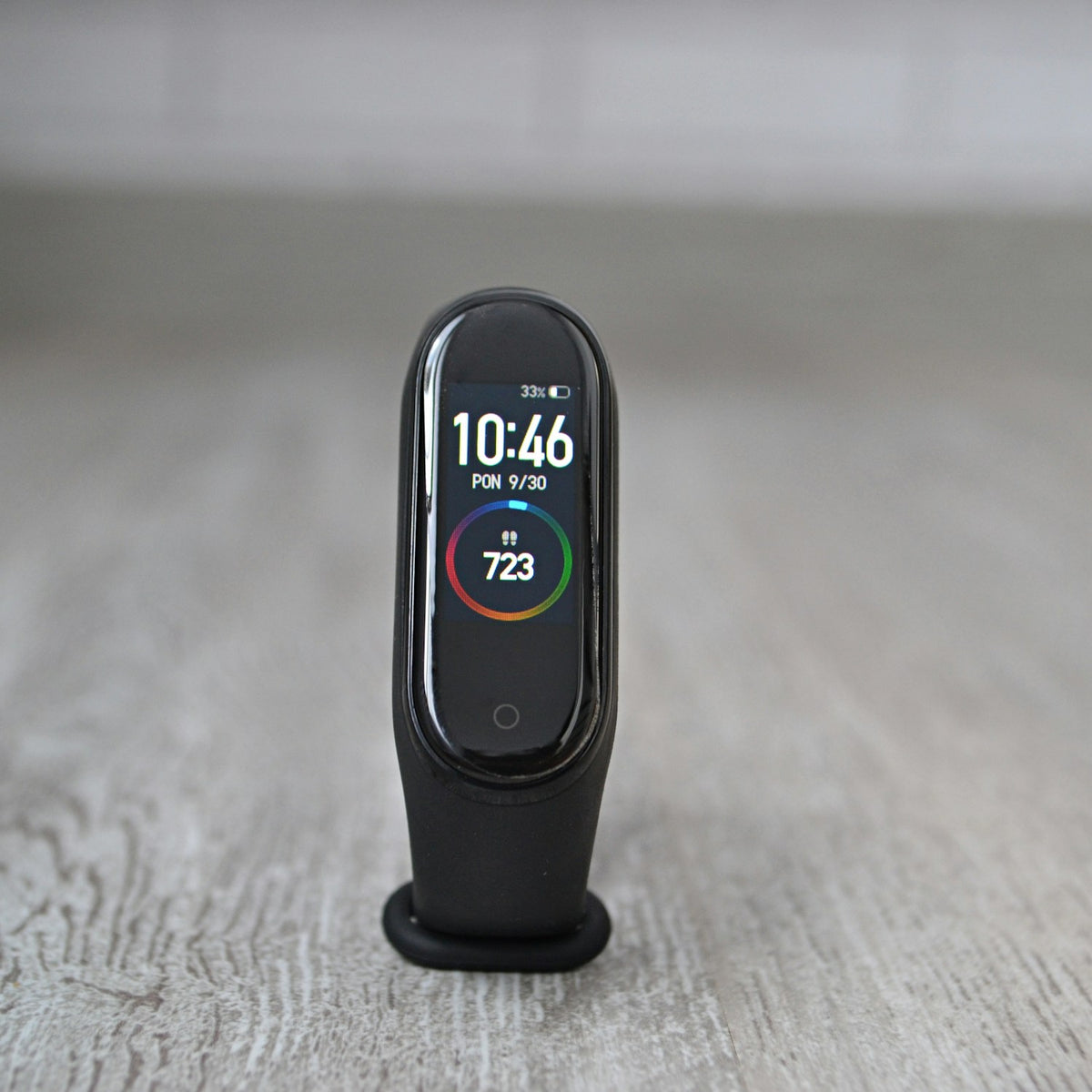 Xiaomi Smart Band fitness tracker standing on a wooden floor