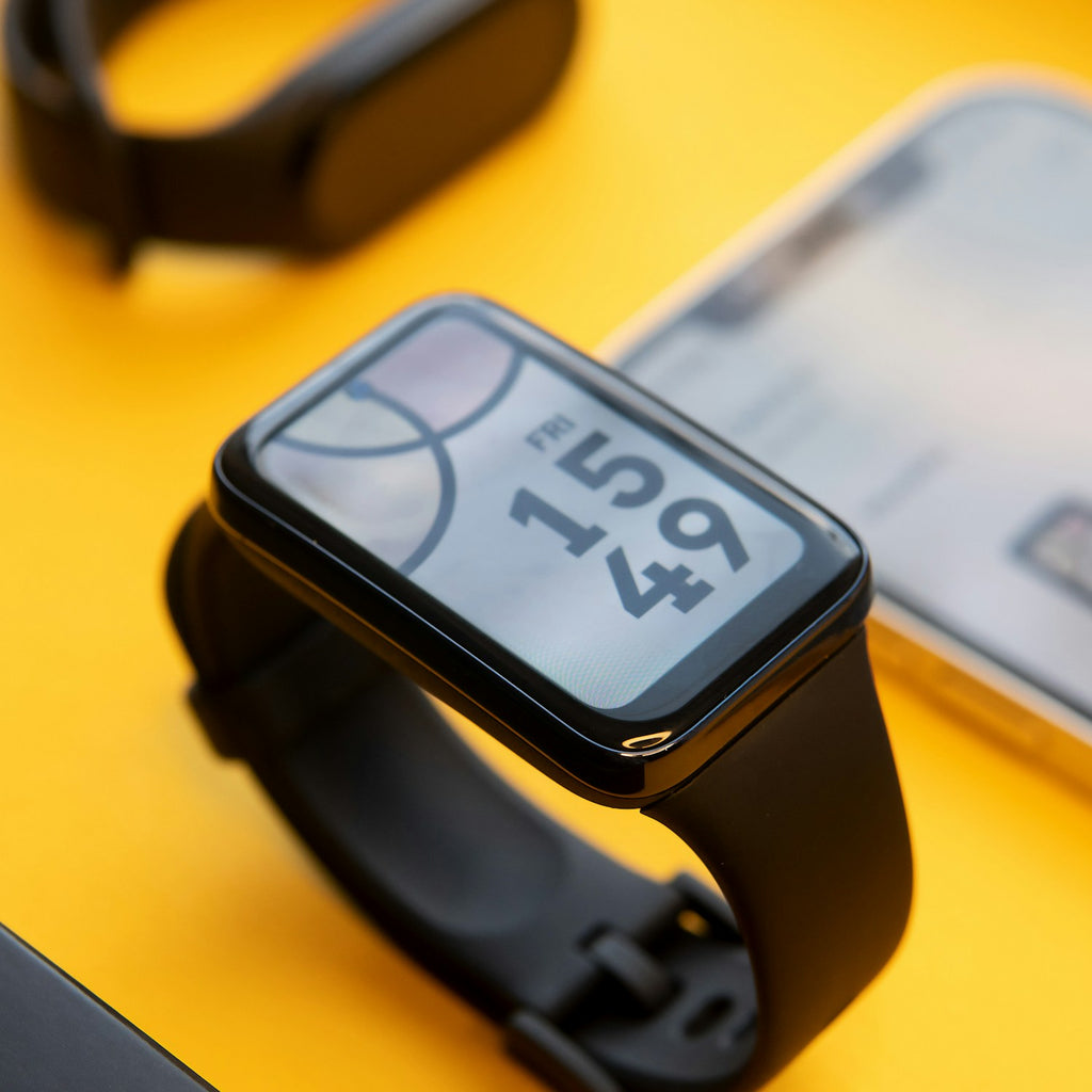 Rectangular AMOLED fitness band on a yellow desk